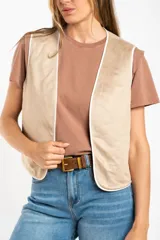 Chaleco sin mangas, color beige claro, con bordados florales en relieve y ribetes a contraste.