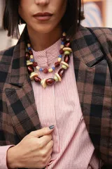 Collar corto de cuentas de resina en tonos marrón rojizo, verde claro y beige, con diseño de esferas y discos intercalados.
