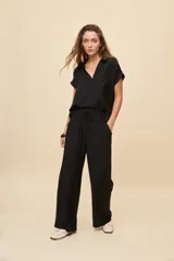 Pantalón gris de corte amplio y silueta fluida, con cintura elástica y cordón ajustable.