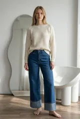 Sweater de tejido de punto con textura tipo waffle, color crudo, de corte clásico con cuello redondo y mangas largas con puños acanalados.