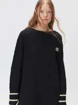 Sweater de punto con diseño de rombos en relieve, cuello redondo y calce holgado. Presenta aberturas laterales en el ruedo y logo bordado en el pecho.