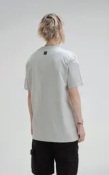 Remera de manga corta y cuello redondo, color gris claro, con calce regular y un recorte sutil en la espalda. Confeccionada en algodón premium suave.