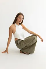 Pantalón color beige de lino, con elástico y tira ajustable en la cintura, bolsillos a ambos lados y pata de elefante estilo Oxford.
