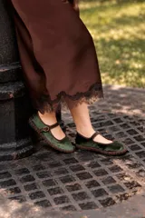 Ballerinas Mary Jane de terciopelo verde oscuro, con ribetes en contraste y tira en el empeine con hebilla metálica.