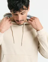 Buzo tipo canguro con capucha, cordones ajustables y bolsillo frontal amplio.