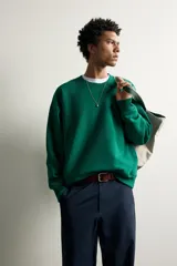 Sudadera de corte regular fit en color verde, con cuello redondo, manga larga raglán y acabados en rib elástico en cuello, puños y dobladillo.