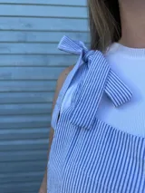 Mono largo de corte holgado con diseño de rayas verticales finas en azul y blanco. Presenta breteles anchos para atar sobre los hombros y piernas de corte ancho tipo palazzo.