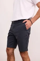 Bermuda de vestir de gabardina color azul marino, de corte regular, con bolsillos laterales y traseros, y cierre frontal con botón y cremallera.