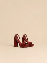 Sandalias de plataforma y taco alto de charol negro, con tira delantera ancha, tira ajustable al tobillo con hebilla dorada y talón cerrado.