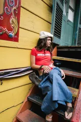 Remera corta roja con cuello redondo, manga corta y estampado frontal con la frase "latina baby" en azul.