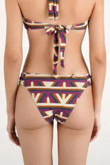 Calzón de bikini con diseño geométrico multicolor y argollas de madera en los laterales.