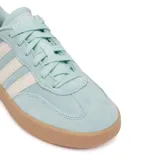 Championes urbanos Adidas modelo Barreda, color verde agua con las icónicas tres tiras laterales en color crema. Presentan un diseño inspirado en el tenis con puntera estilo T-Toe, confeccionados en una combinación de gamuza y cuero sintético, con suela cupsole de goma en color caramelo.