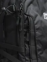 Mochila negra con múltiples bolsillos y correas ajustables.