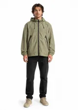 Campera cortaviento de color verde militar, con capucha ajustable con cordón, cierre frontal completo y bolsillos laterales con cierre. Presenta puños elásticos y un diseño ligero.