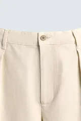 Pantalón relaxed fit color rosado, confeccionado en tejido de algodón con efecto lavado. Presenta pliegues frontales, bolsillos delanteros y bolsillos traseros de vivo. Cierre frontal con cremallera y botón.