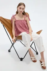 Musculosa de lino con estampado de cuadros vichy en rojo y blanco, escote recto y tirantes anchos con lazos para anudar en los hombros.