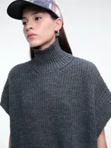 Chaleco tipo poncho de tejido de punto color tostado, con cuello polera y diseño holgado con laterales abiertos.