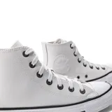 Championes de caña alta Converse modelo Chuck Taylor All Star, confeccionados en cuero blanco con puntera de goma y suela con franjas negras.