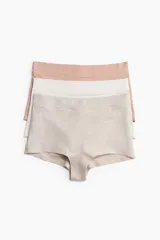 Pack de tres bombachas tipo shortie de algodón, tiro alto, con piernas de corte bajo y refuerzo interior. Los colores son beige melange, blanco y rosado pálido.