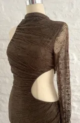 Vestido corto marrón con textura arrugada, cuello alto asimétrico y una manga larga. Presenta un corte en la cintura.