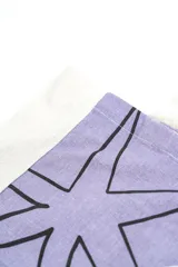 Bolso tipo tote bag de color crudo con estampado de flores celestes y centros azul oscuro. Cuenta con doble asa de hombro en tono crudo y etiqueta con la marca en el frente.