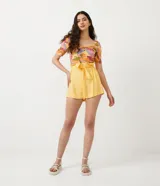Short clochard amarillo de lino, con cintura alta, ajuste con lazo y bolsillos laterales.