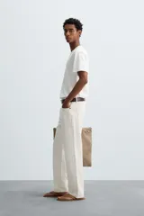 Camiseta de algodón de peso medio, color gris oscuro con efecto lavado ligero. Presenta cuello redondo y manga corta.