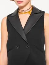 Chaleco negro confeccionado en powermar, con cuello y solapa en cuero ovino. Incluye broches metálicos, forrería interna en jacquard marcario y bolsillos ojales en el delantero.