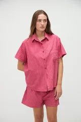 Camisa de manga corta de algodón con diseño a rayas en tonos amarillo y blanco, calce holgado, cuello solapa y bolsillo aplicado en el pecho.