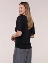 Blusa blanca con escote redondo y mangas cortas estilo mariposa confeccionadas en tela plisada translúcida.