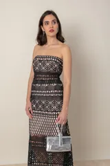 Vestido largo de fiesta negro con forro color nude y encaje calado con motivos geométricos. Diseño strapless con transparencia en cintura y ruedo.