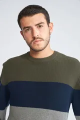 Sweater de tejido de punto con diseño color block en tonos verde, azul y gris. Presenta cuello redondo, mangas largas y corte regular.