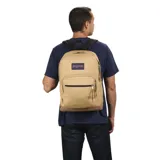 Mochila Jansport Right Pack color beige con base de cuero marrón. Tiene un compartimento principal con cierre, un bolsillo frontal con cierre, un asa de mano superior y correas acolchadas ajustables para los hombros. El logo de Jansport está bordado en la parte delantera.