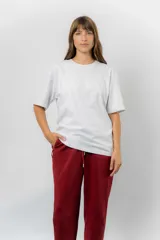 Remerón de algodón color gris melange, con corte oversize, cuello redondo, mangas cortas amplias y hombros caídos. Presenta una textura sutil en la parte superior delantera.