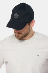 Gorro con visera de lona color verde oliva con parche circular de goma negro en el frente.