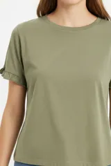 Remera blanca de algodón, de corte ajustado, con cuello redondo y mangas cortas terminadas con volados delicados.