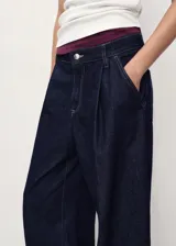 Pantalón de jean estilo wideleg de tiro medio, con pinzas delanteras, cierre de botón y cremallera, y cuatro bolsillos.