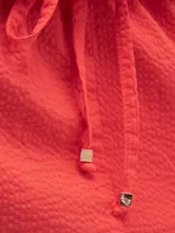 Falda larga color coral, estilo cargo, con cintura ajustable, tajo en el frente y bolsillos laterales.