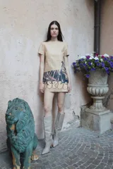 Vestido corto color beige confeccionado en cuero, con escote redondo, manga corta y estampa de tigre y letras en la falda.