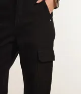Pantalón de sarga color verde oliva con corte recto y tiro alto. Presenta bolsillos cargo laterales con solapa y cierre frontal con botón y cremallera.