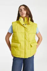 Chaleco puffer amarillo con cuello alto, cierre frontal con cremallera y broches a presión, y bolsillos delanteros con solapa.