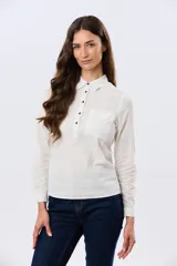 Camisa de lino lisa color celeste, de manga larga con puños abotonados y trabilla para arremangar. Cuenta con cuello clásico, cierre frontal con botones y bolsillos plaqué en el pecho.