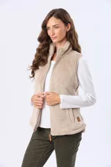 Chaleco de tejido sherpa color beige, con cuello alto y detalles en eco cuero. Diseño sin mangas que proporciona abrigo al torso manteniendo la libertad de movimiento.