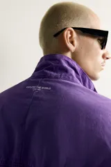 Cazadora relaxed fit de denim de algodón en color violeta, con efecto lavado, cuello alto, cierre frontal de cremallera y bolsillos en las costuras laterales. Presenta puños y dobladillo elásticos.
