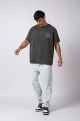 Remera oversize de algodón con efecto lavado gastado, cuello redondo y mangas cortas. Presenta un diseño circular estampado en el pecho con el texto VCP CONCEPT STUDIO.