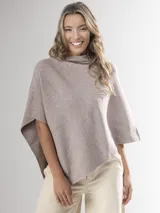 Poncho de corte holgado y diseño minimalista, confeccionado en tejido liviano de color beige, con cuello redondo y caída fluida.