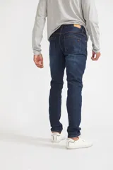 Jean de hombre color gris oscuro, corte recto, con roturas y logo bordado.