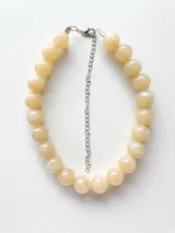 Collar corto de cuentas esféricas grandes con efecto marmolado en tonos beige y marfil, con cadena de extensión plateada y cierre de mosquetón.