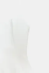 Top negro ajustado al cuerpo con escote recto y tirantes finos. Presenta un bajo con corte peplum.