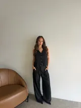 Pantalón de vestir negro, de corte ancho y relajado, con tiro alto y bolsillos laterales.